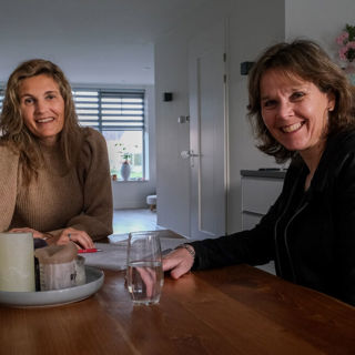 Twee vrouwen zitten samen aan tafel