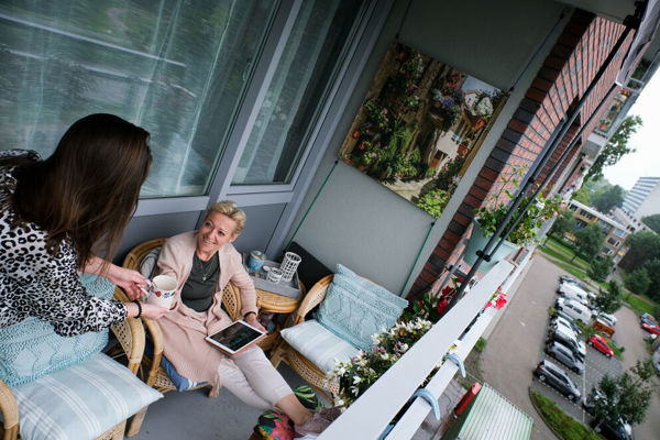 Twee dames drinken samen een kopje koffie op het balkon