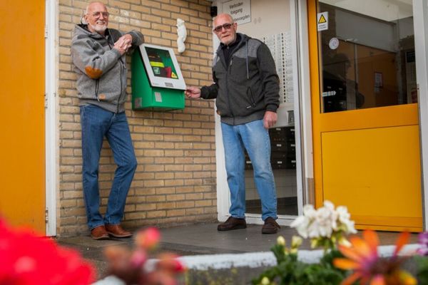 Twee mannen staan bij een aed-apparaat