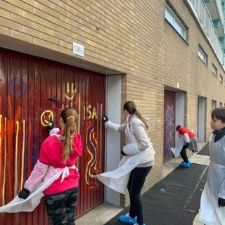 Jongeren sprayen graffiti op een garagedeur