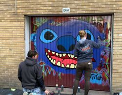Jongeren sprayen graffiti op een garagedeur