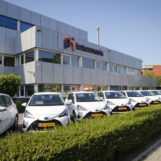 Kantoorpand van Intermaris in Hoorn met witte bedrijfsauto's voor het pand