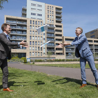 Twee mannen gooien pakketjes over naar elkaar