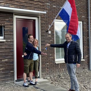 Bewoners ontvangen de sleutel van hun nieuwbouwwoning van een medewerker van Intermaris