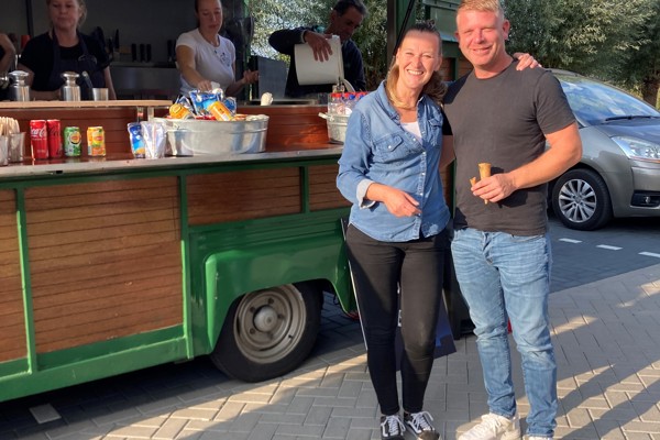 Bewoners staan bij een eetkraam voor het woongebouw