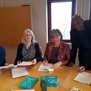 Diverse mensen ondertekenen een samenwerkingsovereenkomst