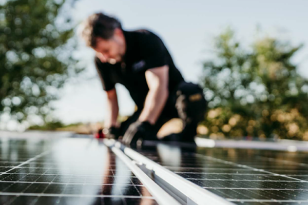 Man legt zonnepanelen op het dak
