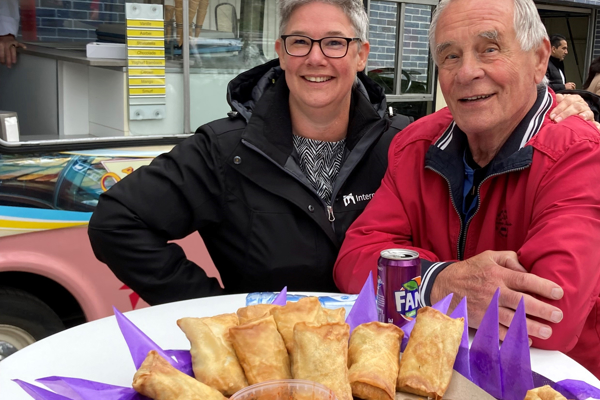 Een man en een vrouw staan bij een schaal met hapjes