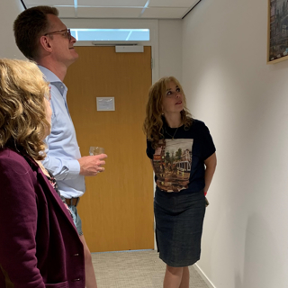Kunstenaar Marcia bekijkt samen met Directeur Intermaris Cees Tip haar kunstwerk aan de muur