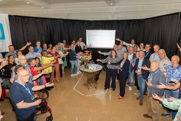 Diverse mensen reiken samen naar een bord met afspraken daarop