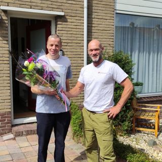 Bewoner krijgt bloemen van een medewerker van Intermaris