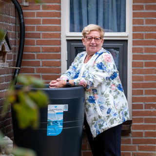 Bewoonster staat bij een regenton