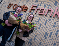 Bewoners met bosjes bloemen staan voor woongebouw de Grote Frank