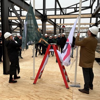 De vlag van Intermaris wordt gehesen bij een nieuwbouw project