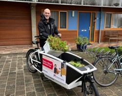 Medewerker Intermaris op de bakfiets met daarin bosjes tulpen