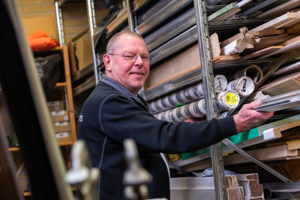 Medewerker van de technische dienst pakt materialen uit het voorraadhok