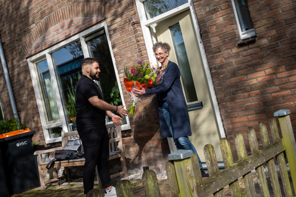 Bewoonster en medewerker Intermaris voor woning met bos bloemen