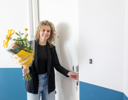 Bewoonster voor woning met bos bloemen in haar hand