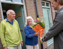 Twee bewoners ontvangen uit handen van directeur Wonen bos bloemen