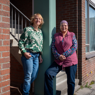 Vriendinnen Lia en Sandra poseren bij woning