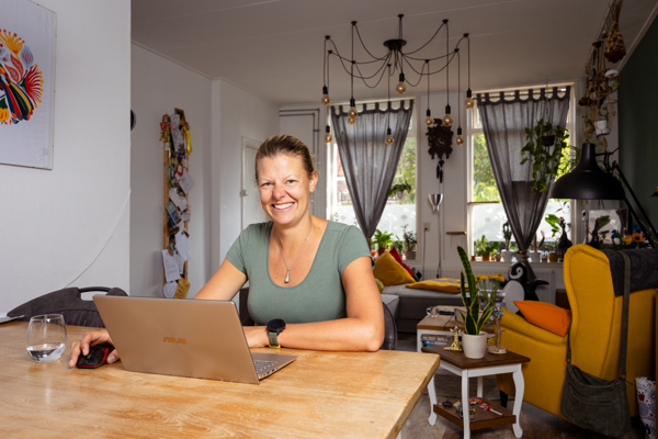 Bewoonster lachend achter laptop