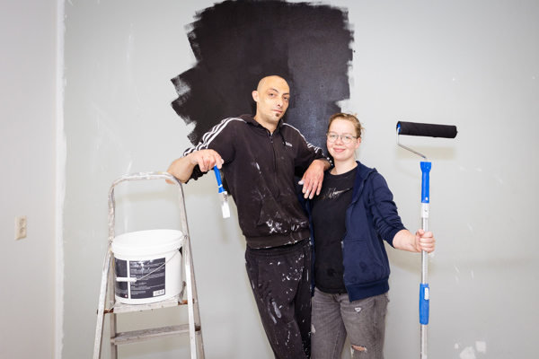 Stel schildert een muur zwart