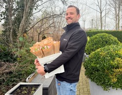 Wijkcoach met bak tulpen in handen