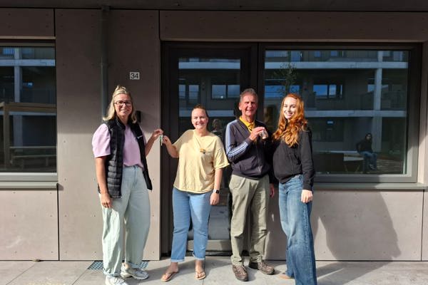 Twee collega's Intermaris reiken sleutel uit aan twee bewoners Blok14